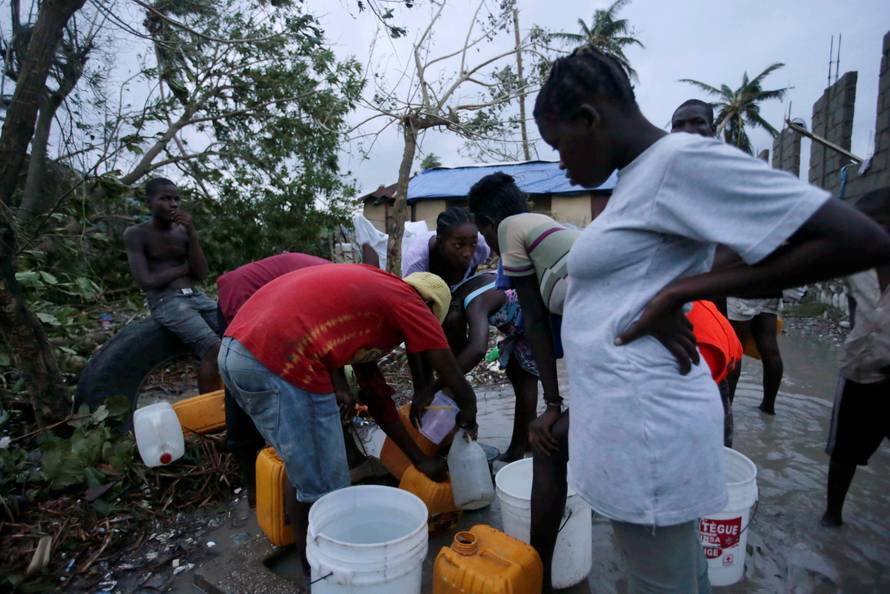 Residents collect water after Hurricane Matthew in Les Cayes