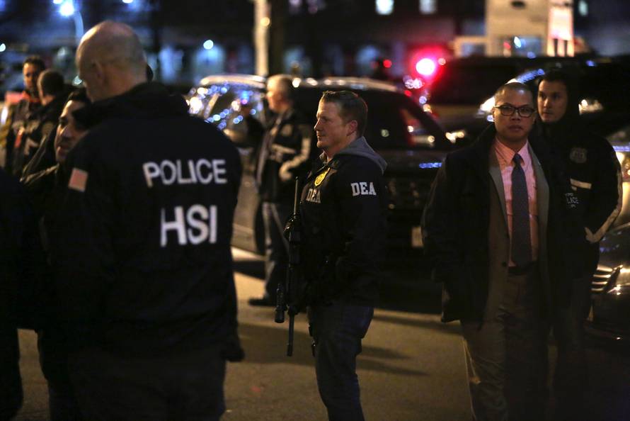 Law enforcement agents assist a motorcade believed to be transporting Joaquin "El Chapo" Guzman at the Manhattan Detention Complex in the Manhattan borough of New York City, New York, U.S.