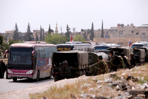 Buses carry rebels and their families who left Douma, at the entrance of Wafideen camp in Damascus