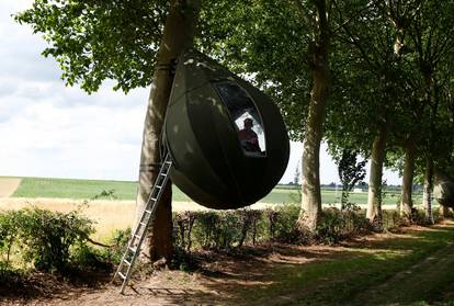 Tear drop-shaped tent hanging from a tree near Borgloon