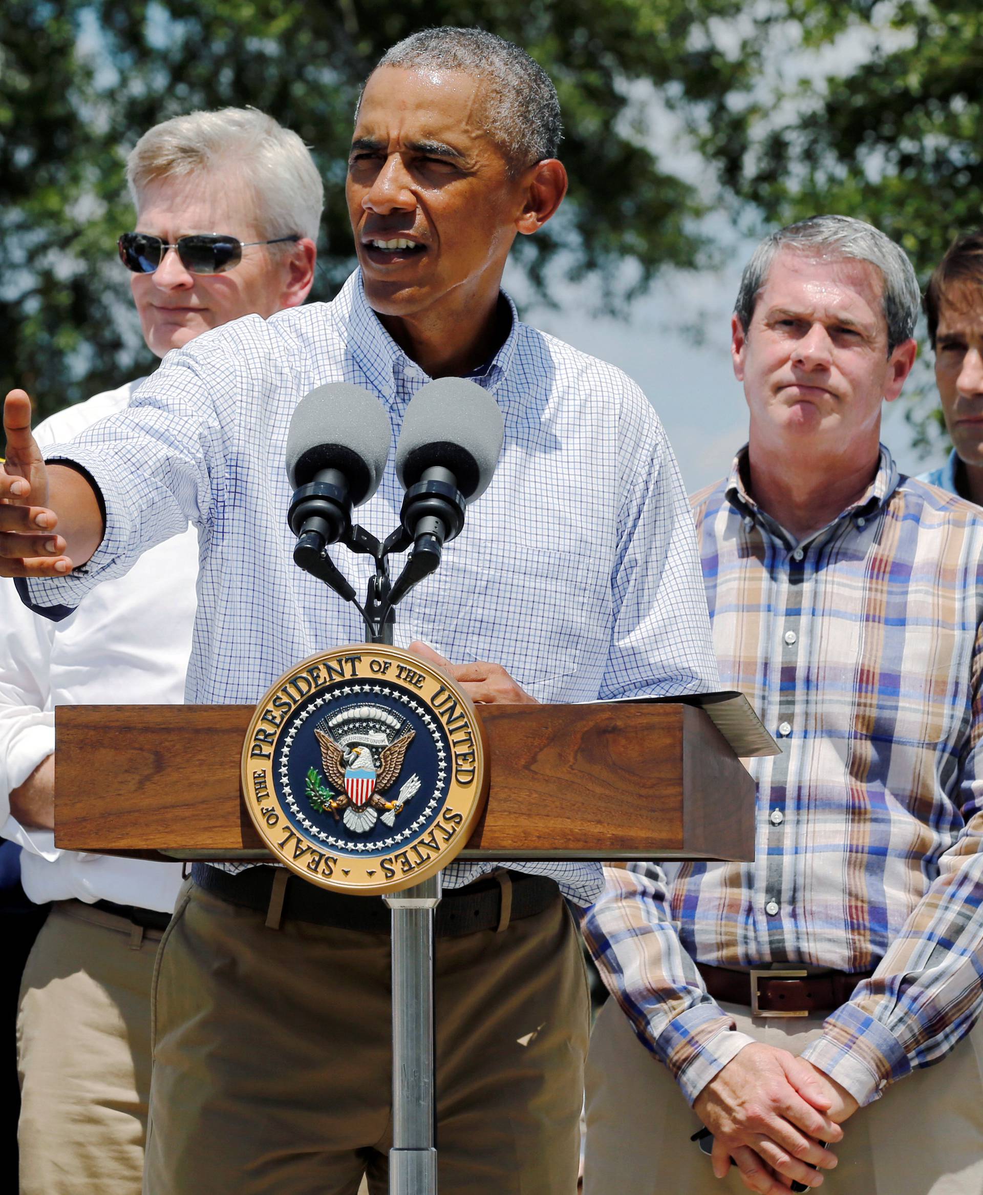 U.S. President Barack Obama, flanked by elected officials including Louisiana Governor John Bel Edwards delivers remarks after touring a flood-affected neighborhood in Zachary