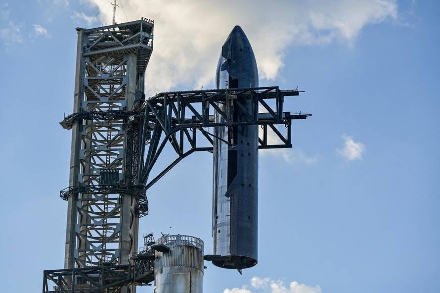 The SpaceX Starship spacecraft is hoisted along the launch tower for stacking atop the Super Heavy booster in preparation for its 11th test flight