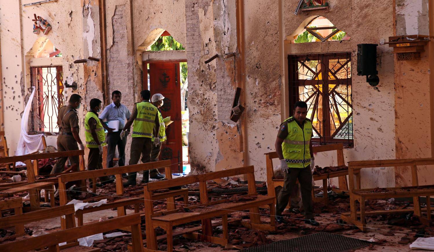 Police officers work at the scene at St. Sebastian Catholic Church in Negambo