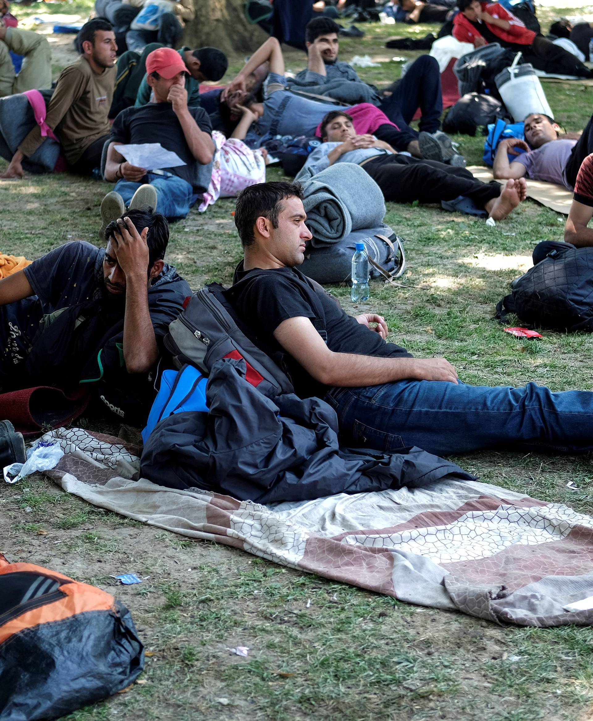 Migrants from the Middle East and Asia rest in a park before they start walking on their way to Hungary in Belgrade