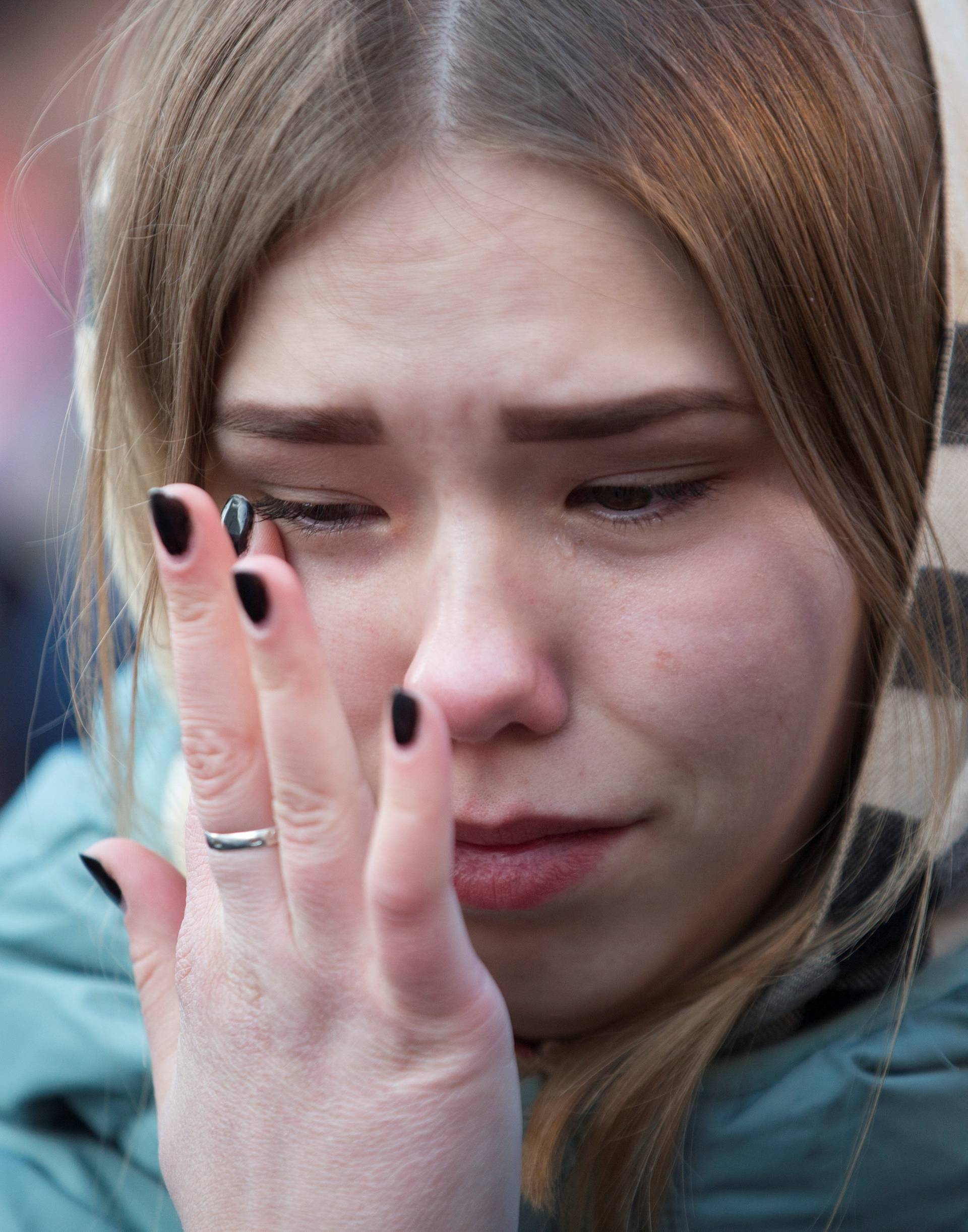 A youth mourns the victims of a shopping mall fire at a makeshift memorial in the Siberian city of Kemerovo