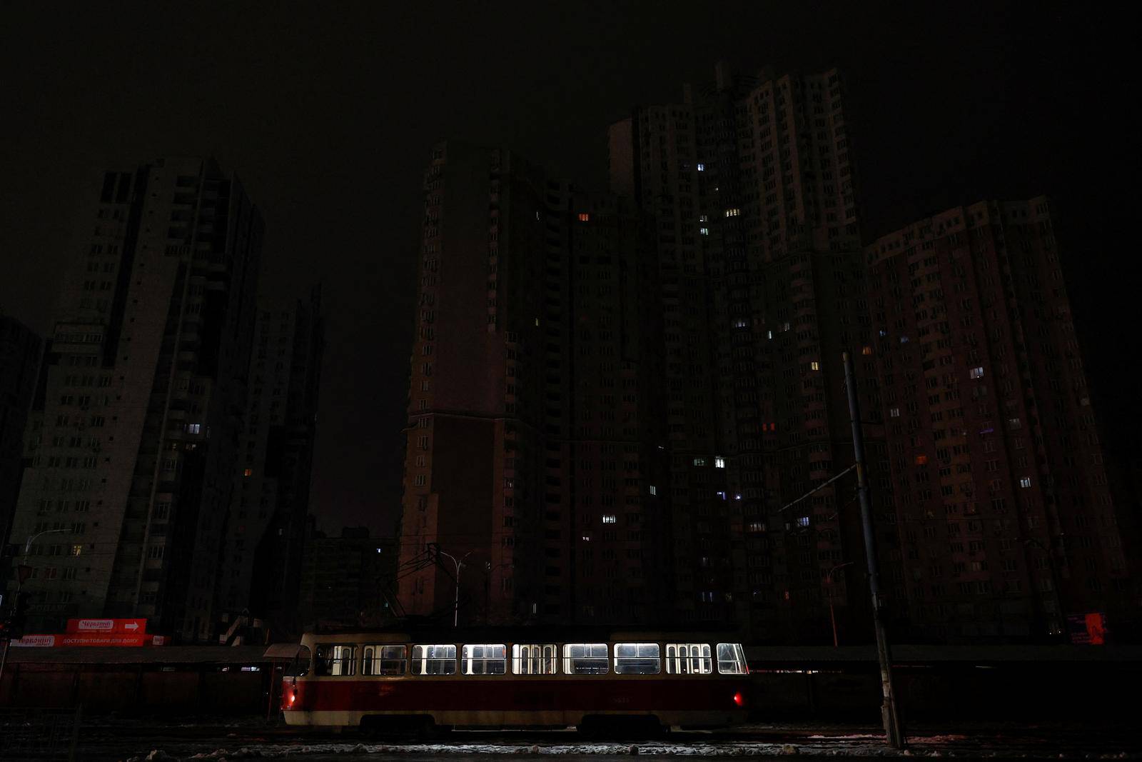 Tram is seen in front of apartment buildings without electricity after critical civil infrastructure was hit by Russian missile attacks in Kyiv