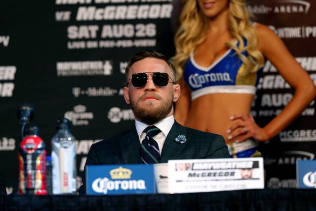 Conor McGregor of Ireland listens to Floyd Mayweather Jr. of the U.S. during a news conference in Las Vegas