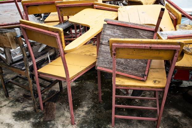 Abandoned broken vintage wooden lecture chairs in old school