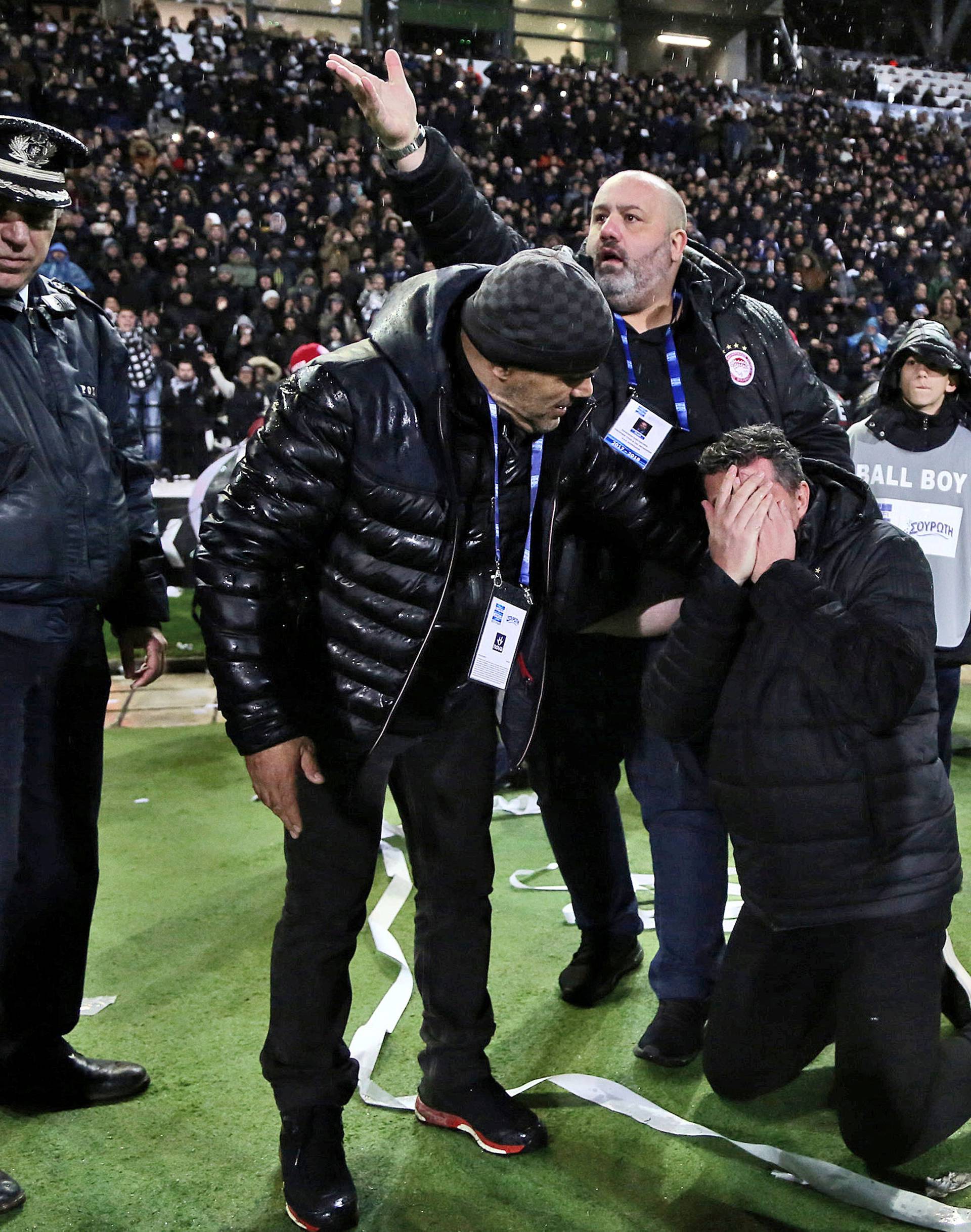 Olympiacos coach Oscar Garcia reacts after his injury during a Greek Super League soccer match between PAOK and Olympiacos in Thessaloniki