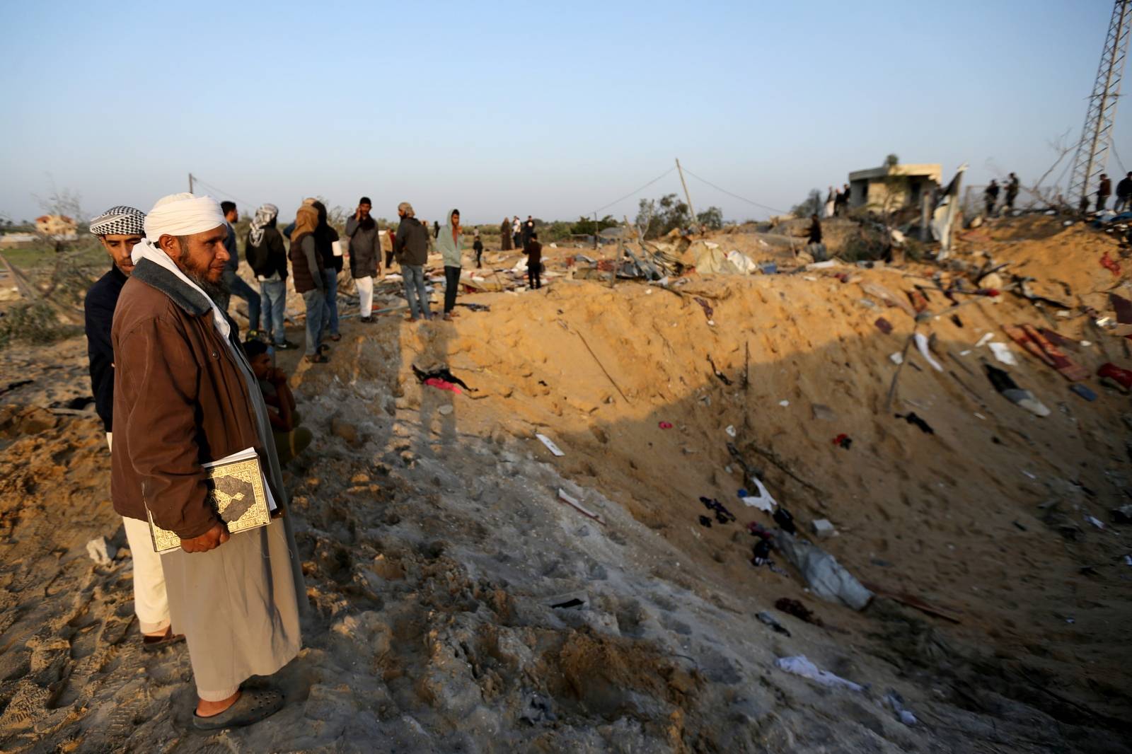 Palestinians gather at the scene of an Israeli air strike in the central Gaza Strip