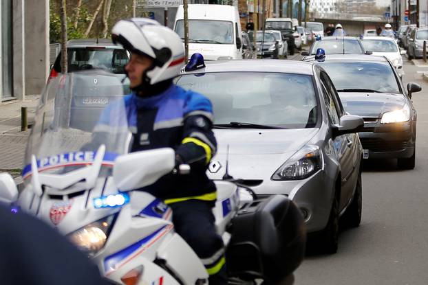 French police escort vehicules believed to transport the sister and brother-in-law of Pascal Troadec as they arrive at the courthouse in Nantes