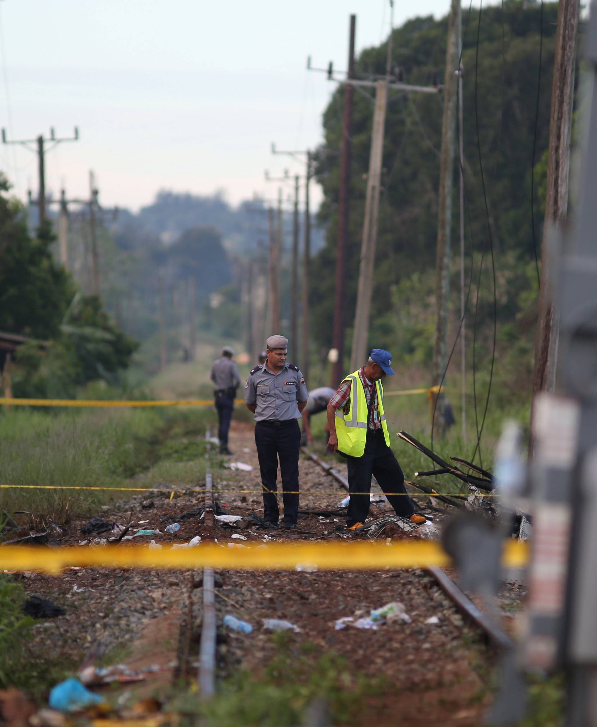 Police officers stand at the site where a Boeing 737 plane crashed after taking off from Havana's main airport yesterday, in the agricultural area of Boyeros