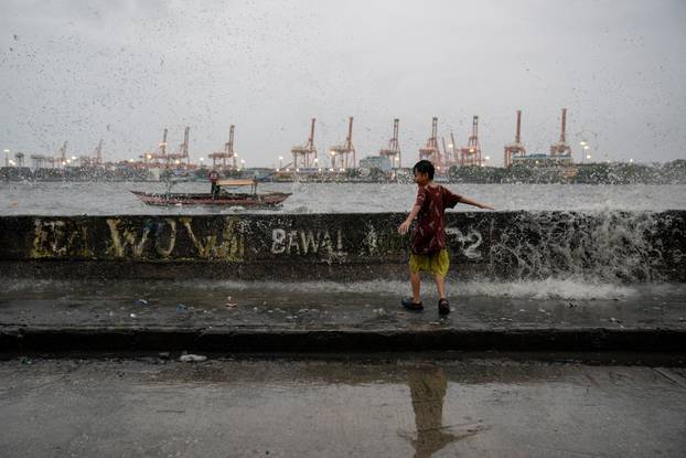 Children play near strong waves amid Super Typhoon Man-yi, in Manila