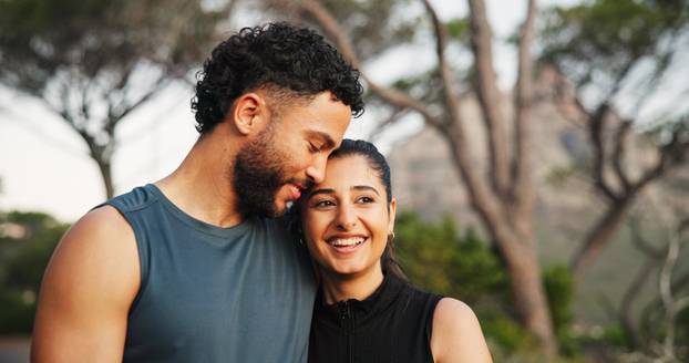 Exercise, hug and smile with couple outdoor together for cardio, health or sports training. Bonding, fitness or love with man and woman embracing in forest for challenge, performance or workout