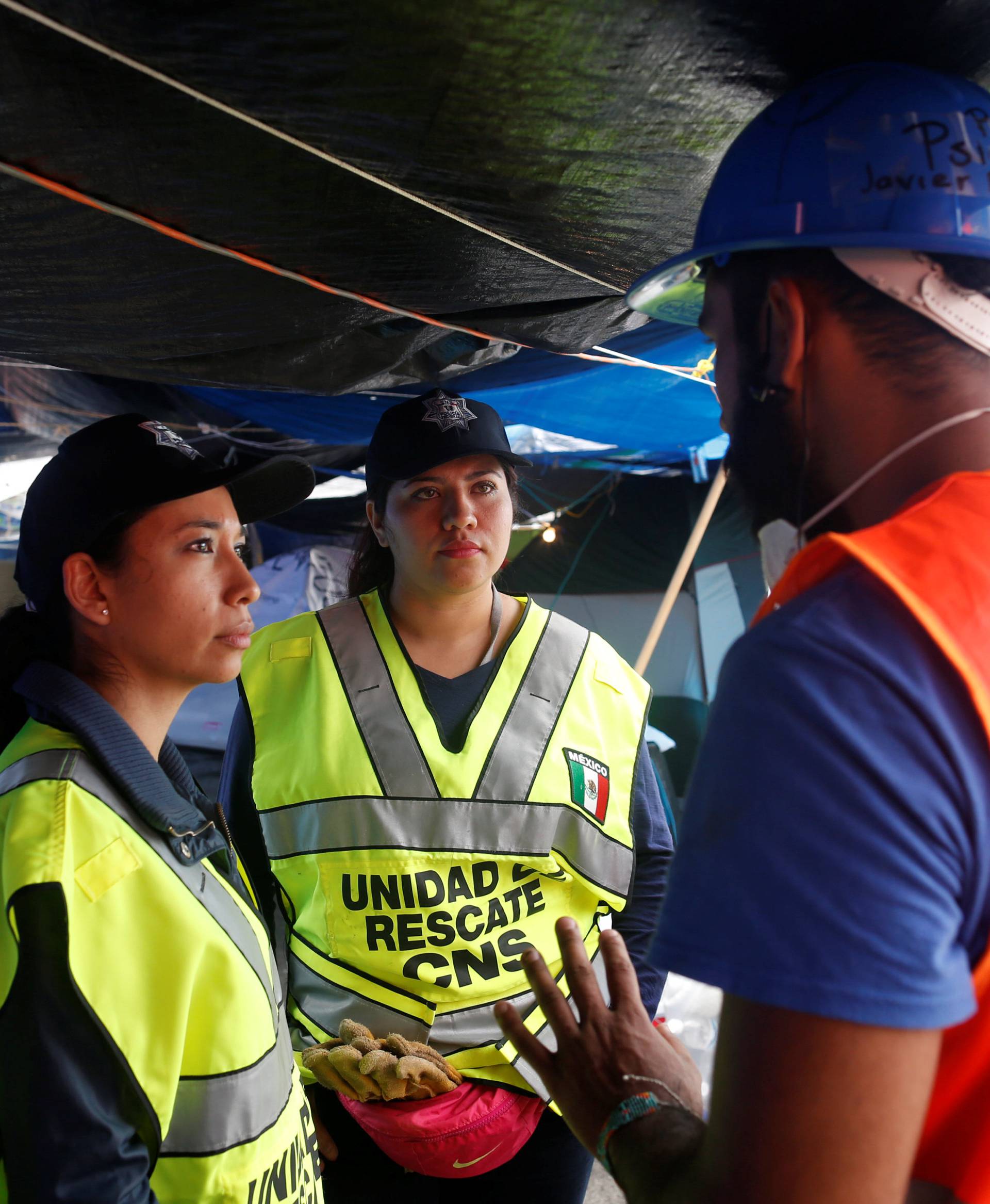 Psychologists from the federal police talk to a rescue worker in a provisional camp after an earthquake in Mexico City