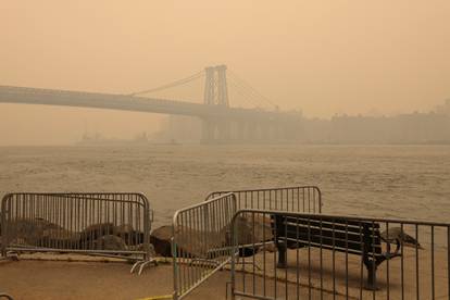 The Williamsburg Bridge is seen covered in haze and smoke caused by wildfires in Canada, in Brooklyn, New York