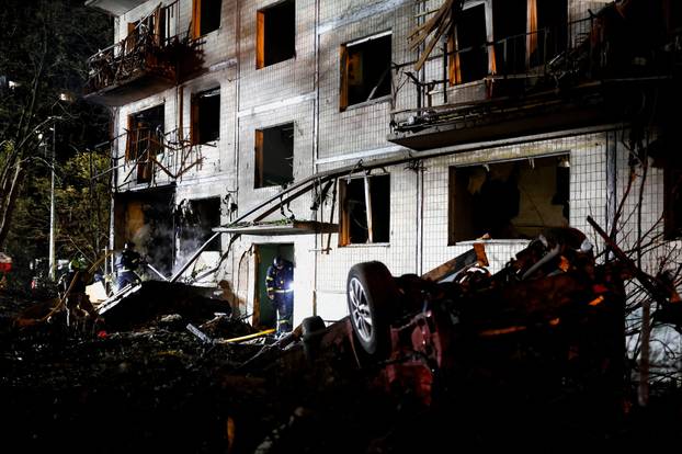 Firefighters work at the site of an apartment building hit by a Russian missile strike in Kyiv