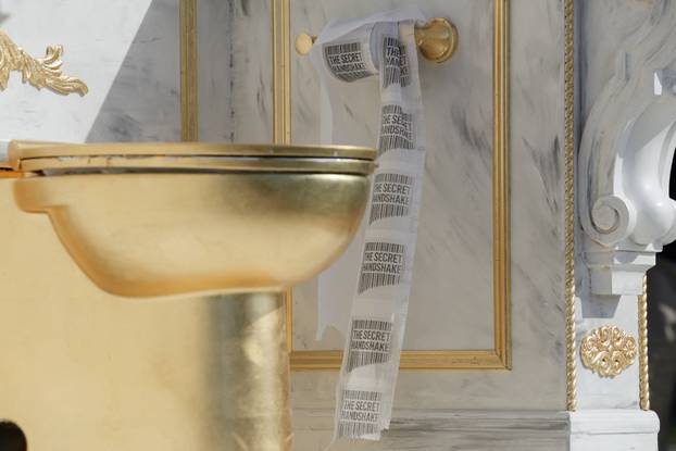 A statue featuring a large golden toilet, titled "A Throne Fit for a King," is displayed in Washington