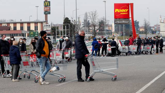 People queue at a supermarket outside the town of Casalpusterlengo