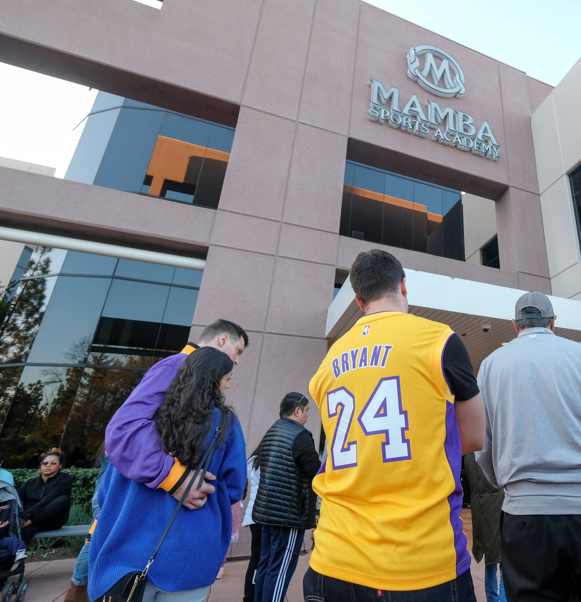 Fans gather at a makeshift memorial for former NBA player Kobe Bryant outside of the Mamba Sports Academy in Thousand Oaks