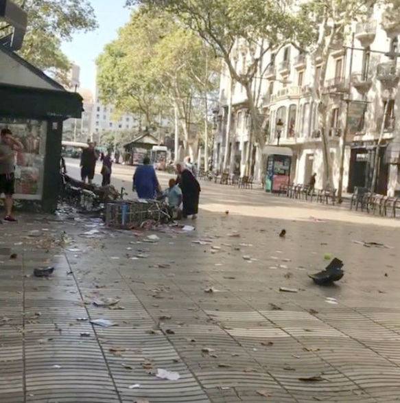 People help an injured person after a van crashed into pedestrians near the Las Ramblas avenue in central Barcelona