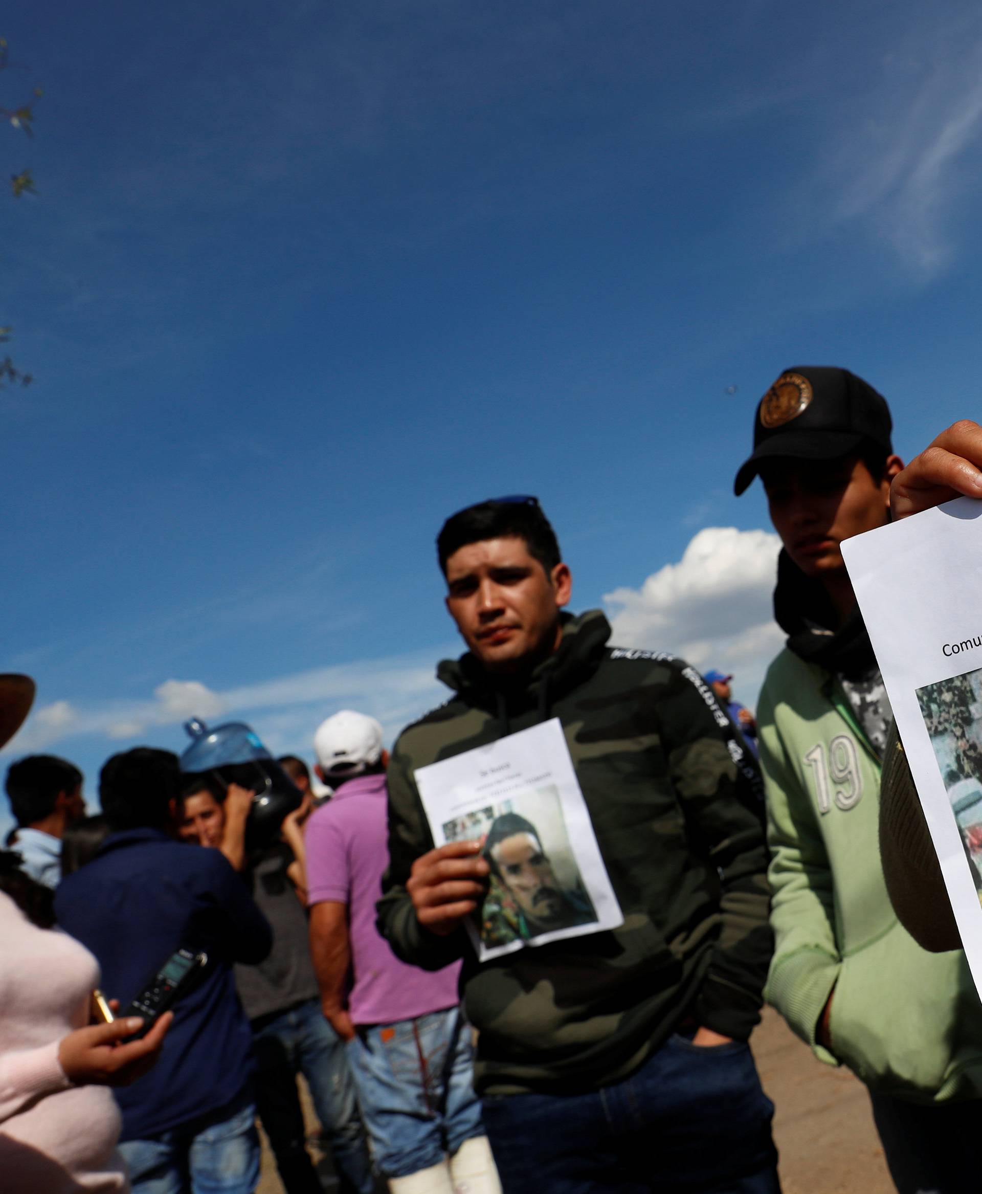 Residents hold pictures of their missing relative at the site where a fuel pipeline ruptured by suspected oil thieves exploded, in the municipality of Tlahuelilpan, state of Hidalgo