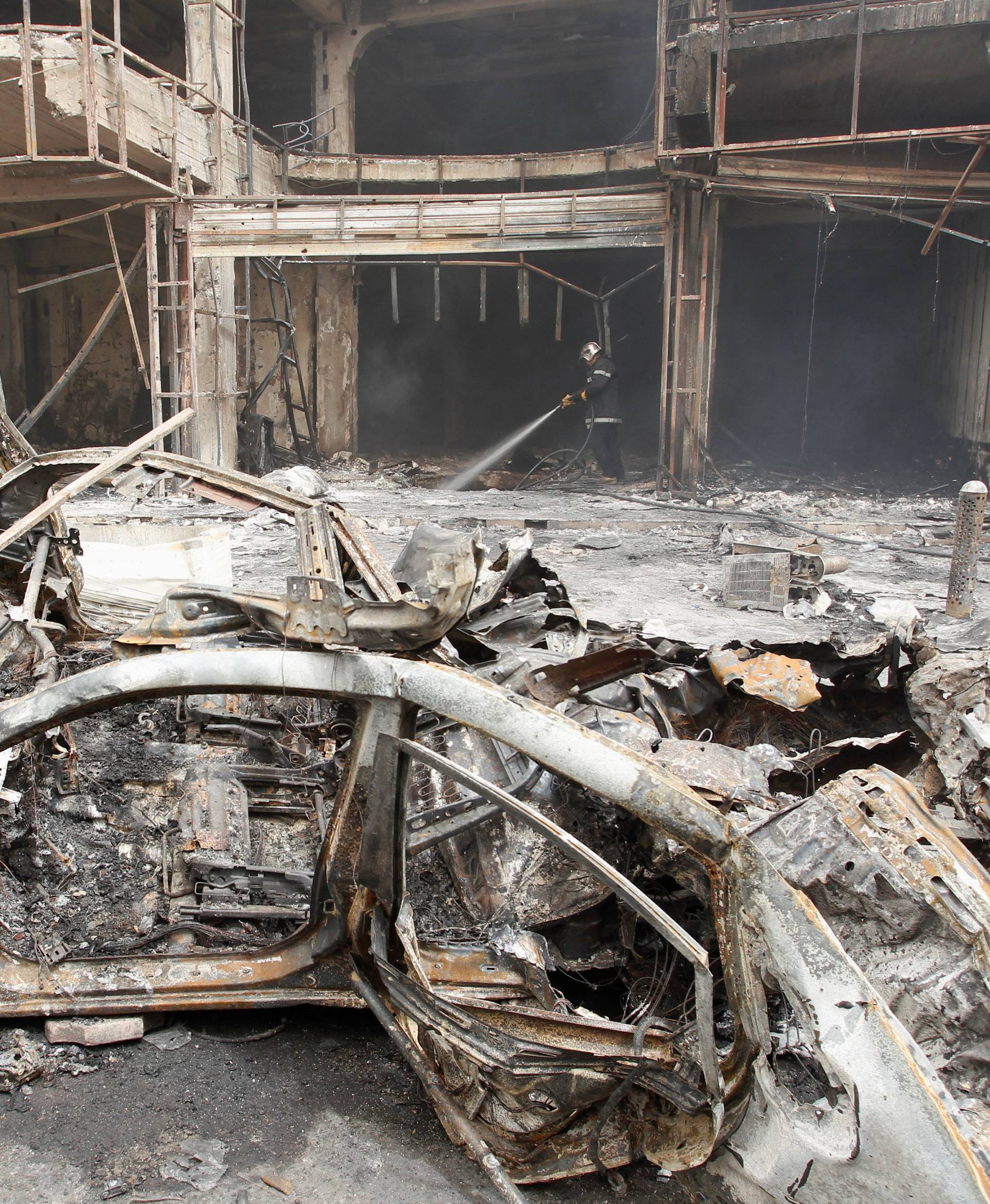 A fireman hoses down a burning building after a suicide car bomb occurred in the Karrada shopping area in Baghdad, Iraq