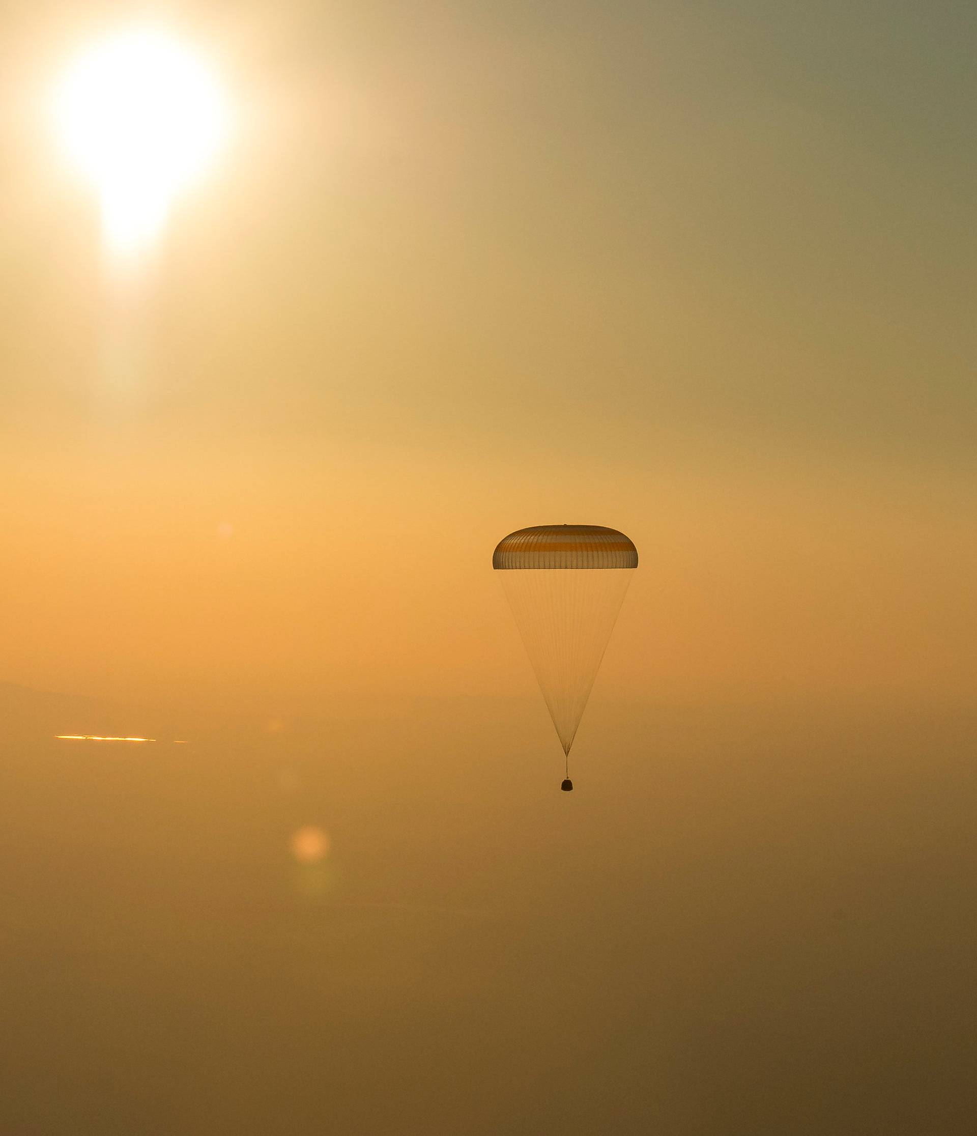 The Soyuz TMA-20M spacecraft capsule carrying International Space Station (ISS) crew descends beneath a parachute near the town of Zhezkazgan (Dzhezkazgan), Kazakhstan