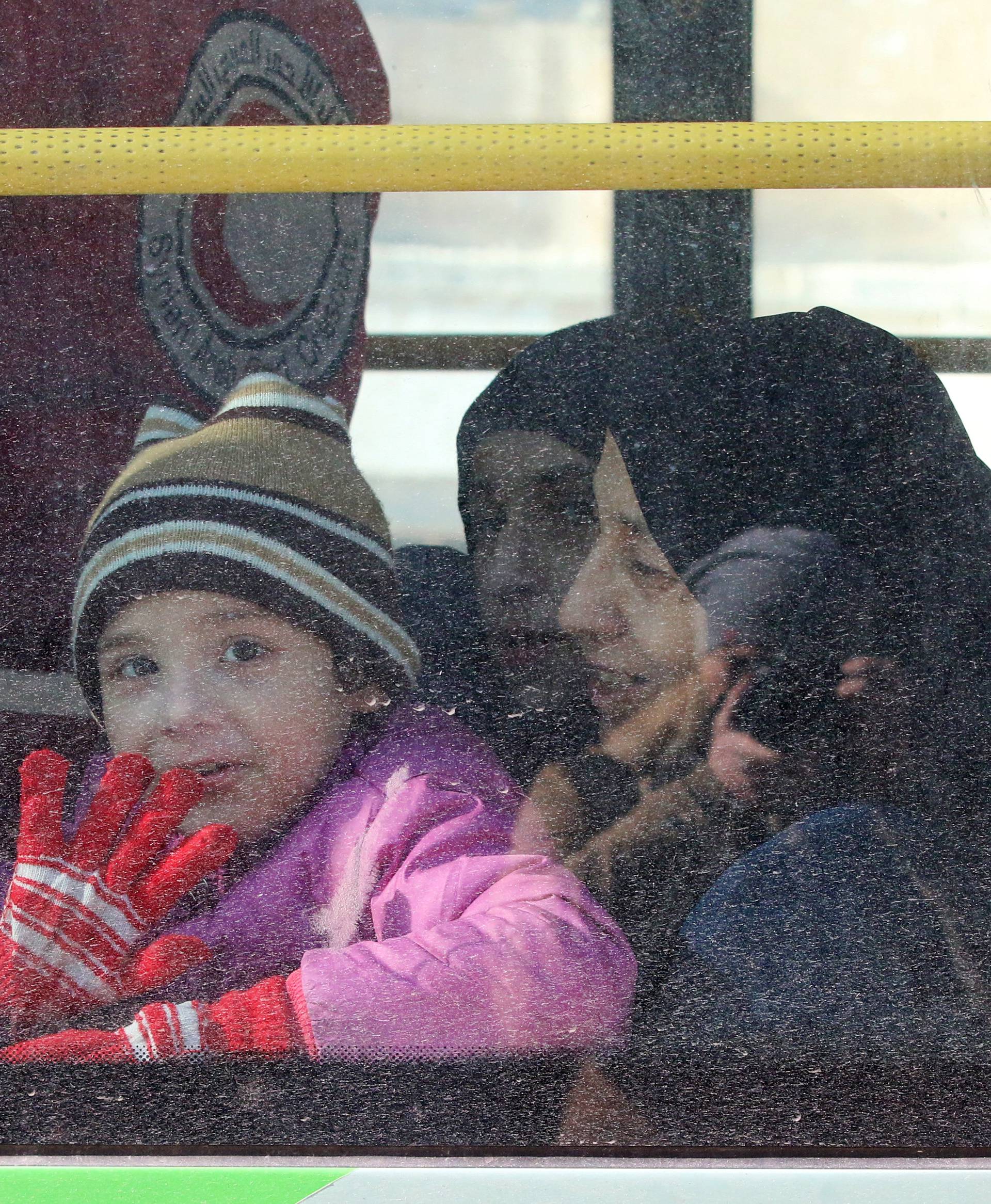 A child reacts from inside a bus evacuating people from a rebel-held sector of eastern Aleppo