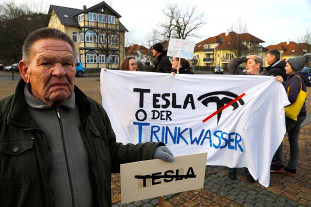 FILE PHOTO: Demonstrators hold anti-Tesla posters during a protest against plans by U.S. electric vehicle pioneer Tesla to build its first European factory and design center near Berli