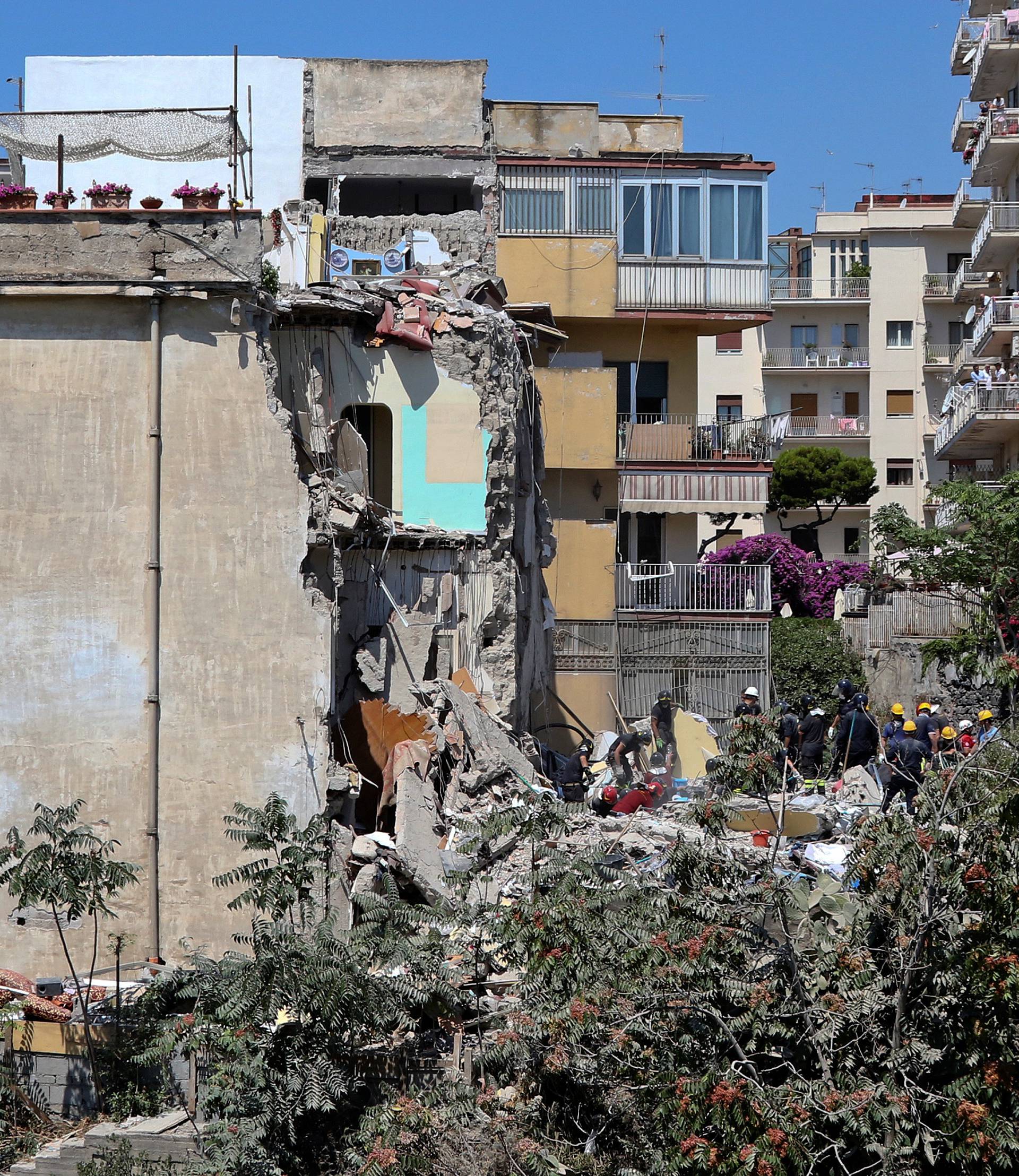 Firefighters work on the site of a collapsed building in Torre Annunziata