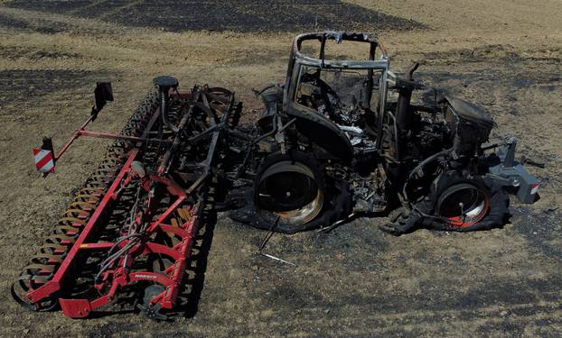 An aerial view shows a burned tractor in a field after a crop fire in La Roche-Blanche