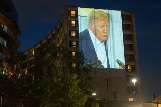 Documents and photos of Jeffrey Epstein and U.S. President Trump projected onto Hilton ahead of WHCA Gala, in Washington, D.C.