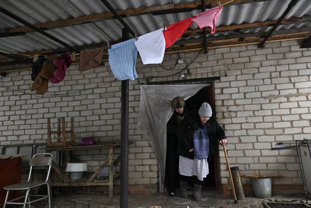 Police officer assists a resident during an evacuation from a frontline village in Zaporizhzhia region