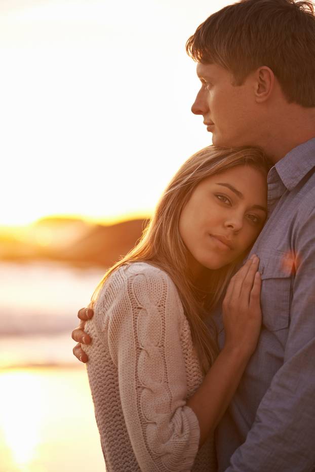 Sentimental sunsets. Portrait of a happy young couple enjoying a romantic embrace on the beach at sunset.