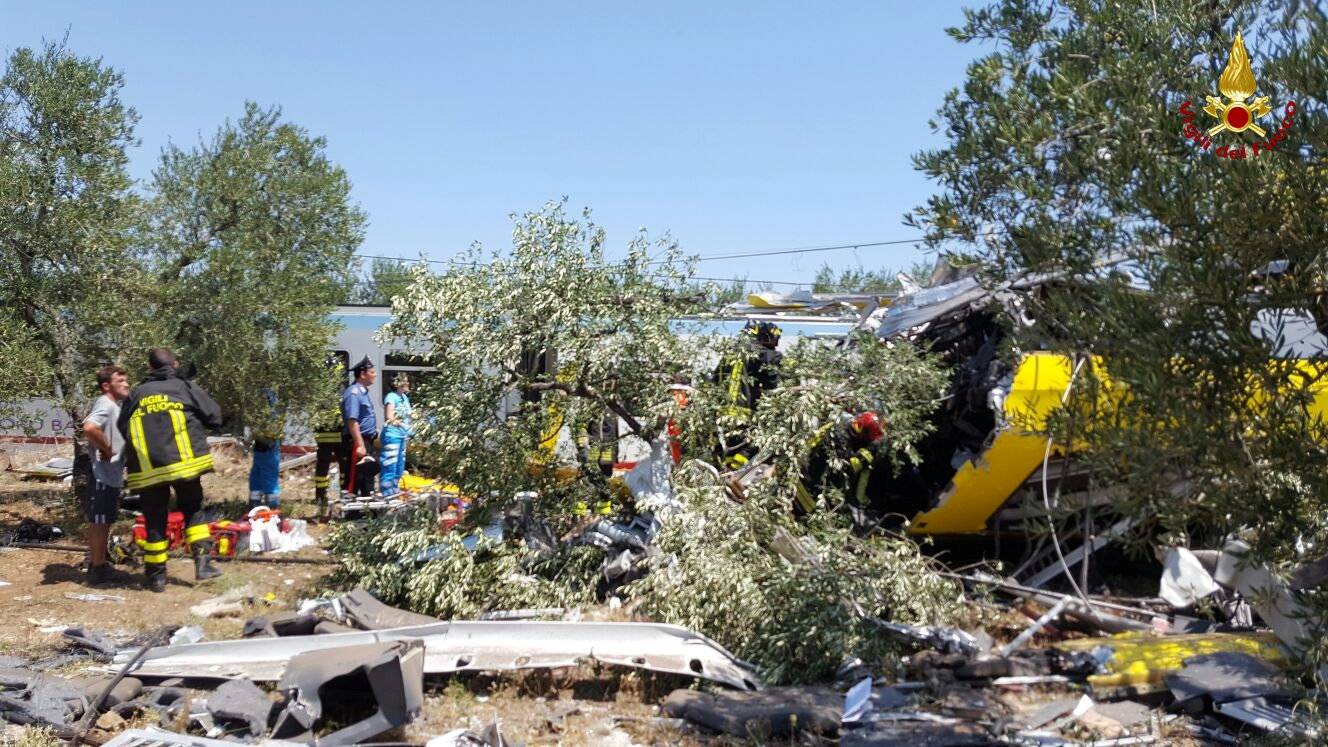 Firefighters work at the site where two passenger trains collided in the middle of an olive grove in the southern village of Corato