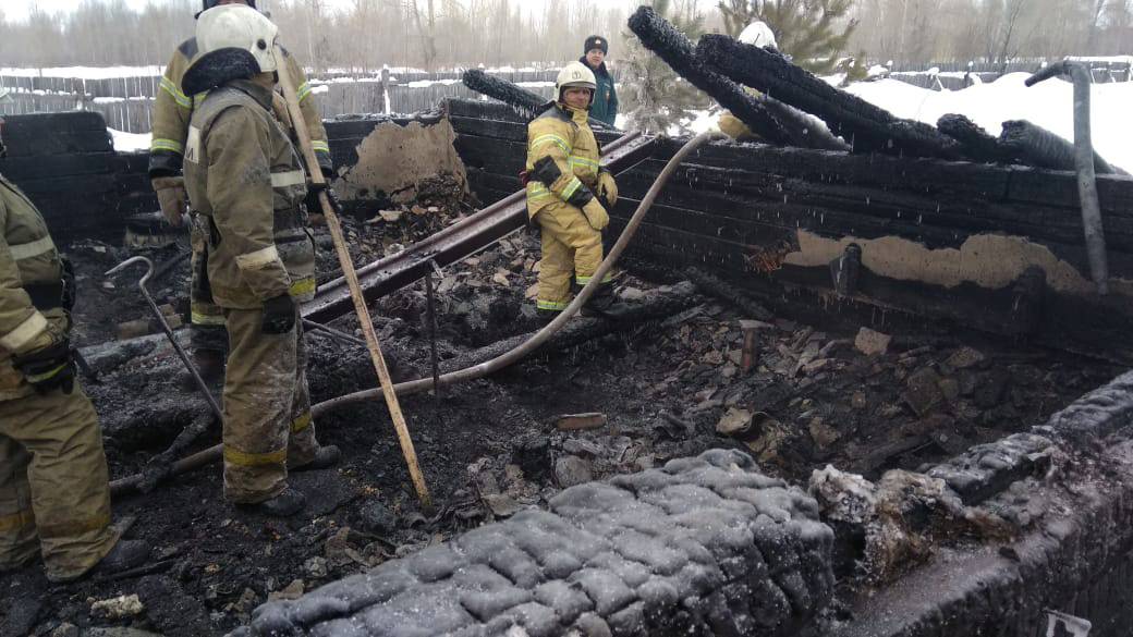 Russian Emergencies Ministry members work at the site of a fire in Tomsk region