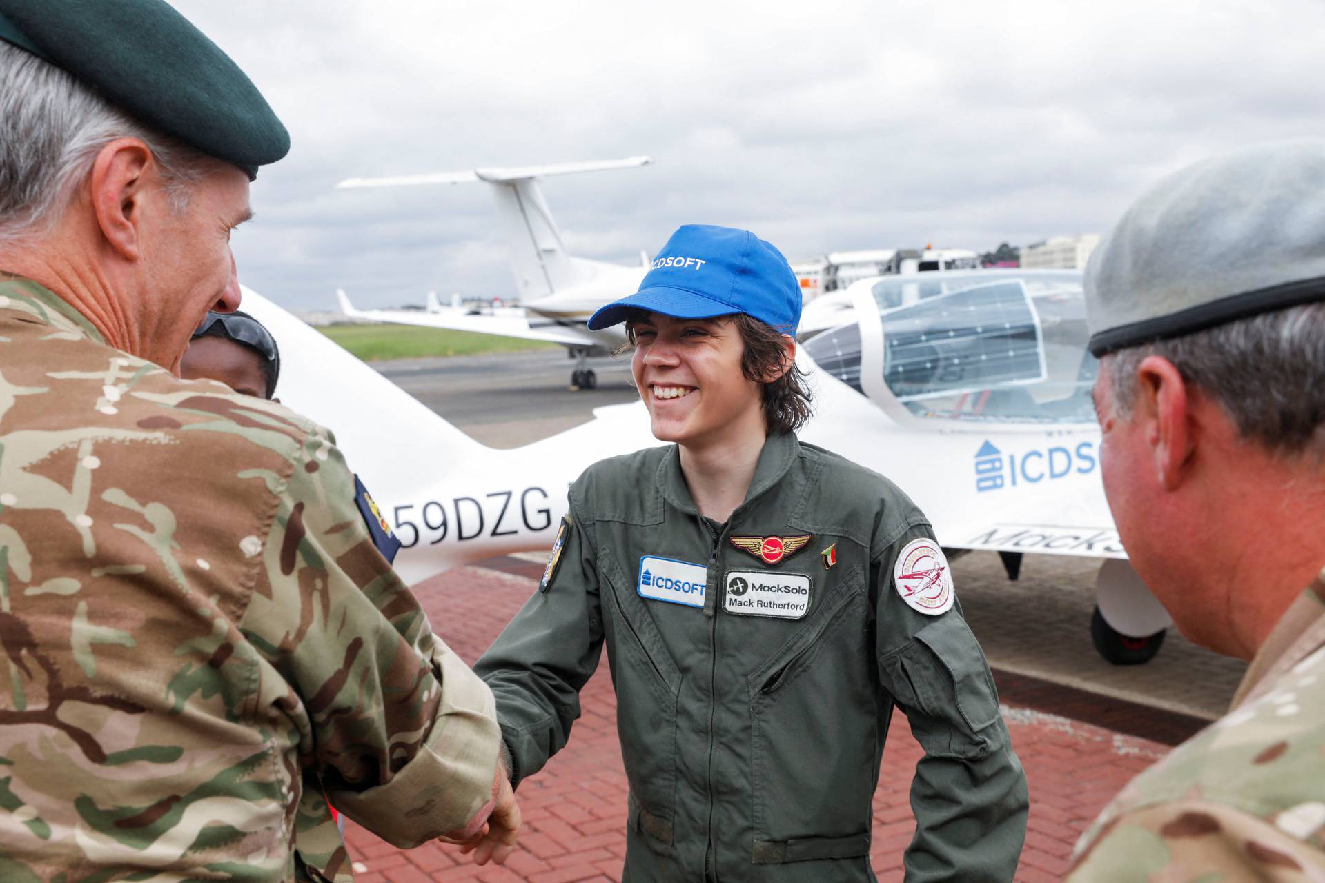 Mack Rutherford, a 16-year-old British-Belgian pilot, is greeted by officers from the British military as he arrives at Wilson airport in Nairobi