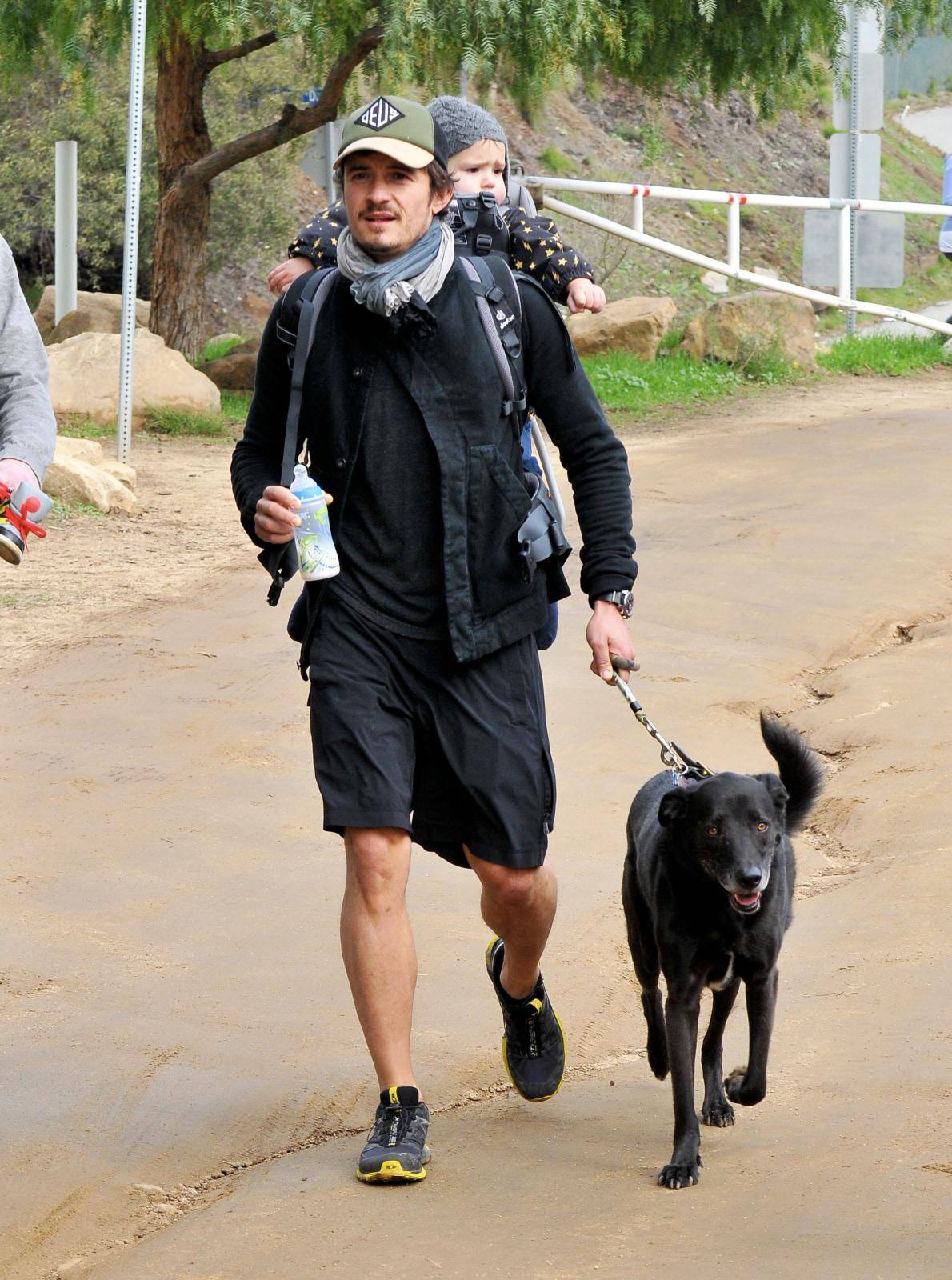 Orlando Bloom carries his son Flynn while walking through Runyon Canyon Park
