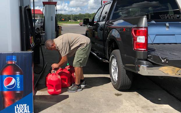 Trent Bullard fills gas containers for his generator ahead of Hurricane Florence in Pembroke North Carolina