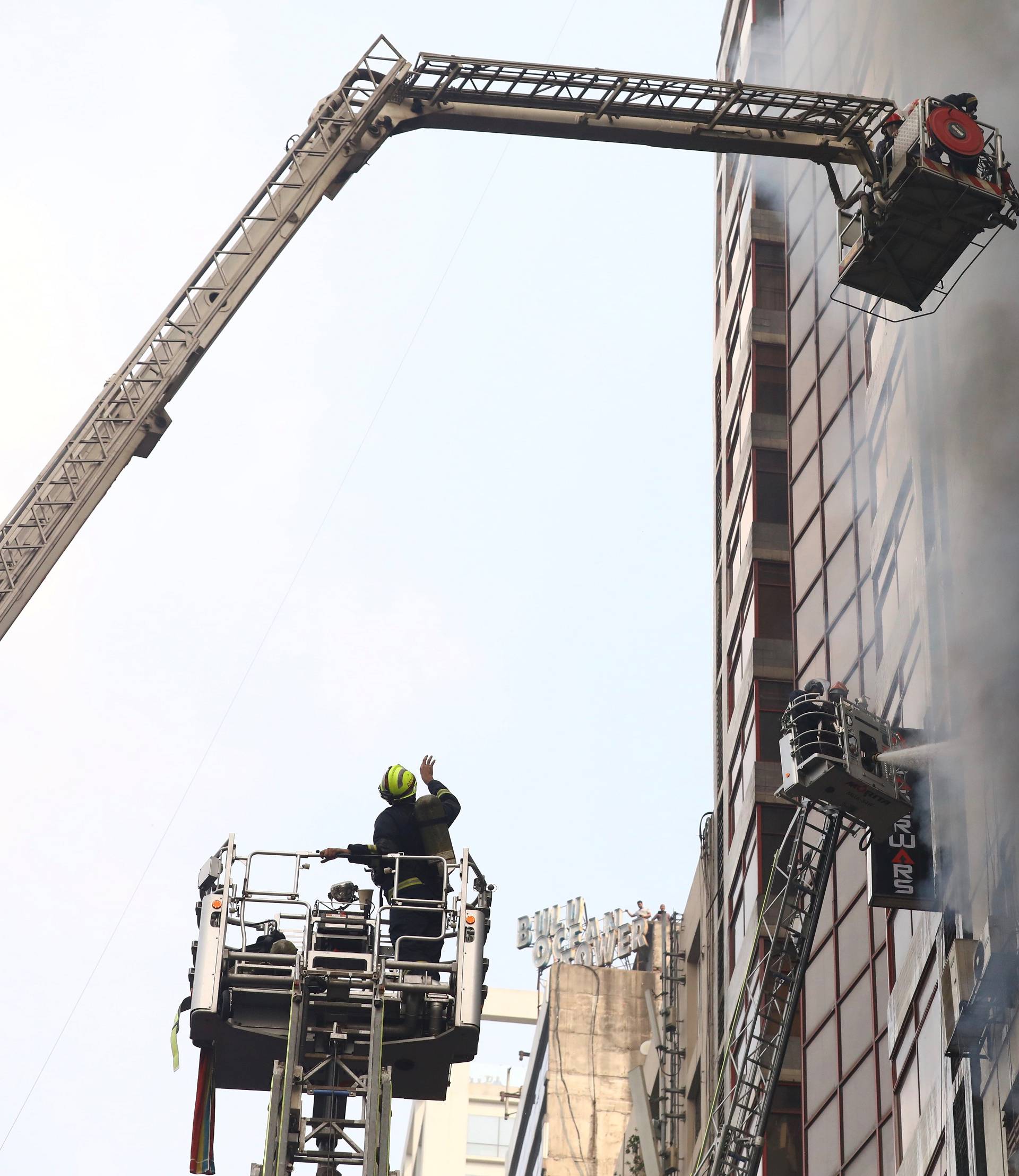 Firefighters attempt to extinguish a fire at a multi-storey commercial building in Dhaka