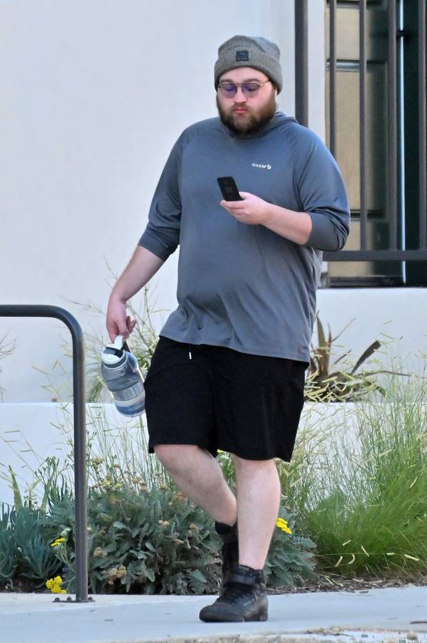 PREMIUM EXCLUSIVE: *NO WEB UNTIL 130PM EDT 31ST AUG* Angus T Jones appears to make a phone call on a FLIP PHONE in rare sighting as he heads to lunch in Los Angeles.