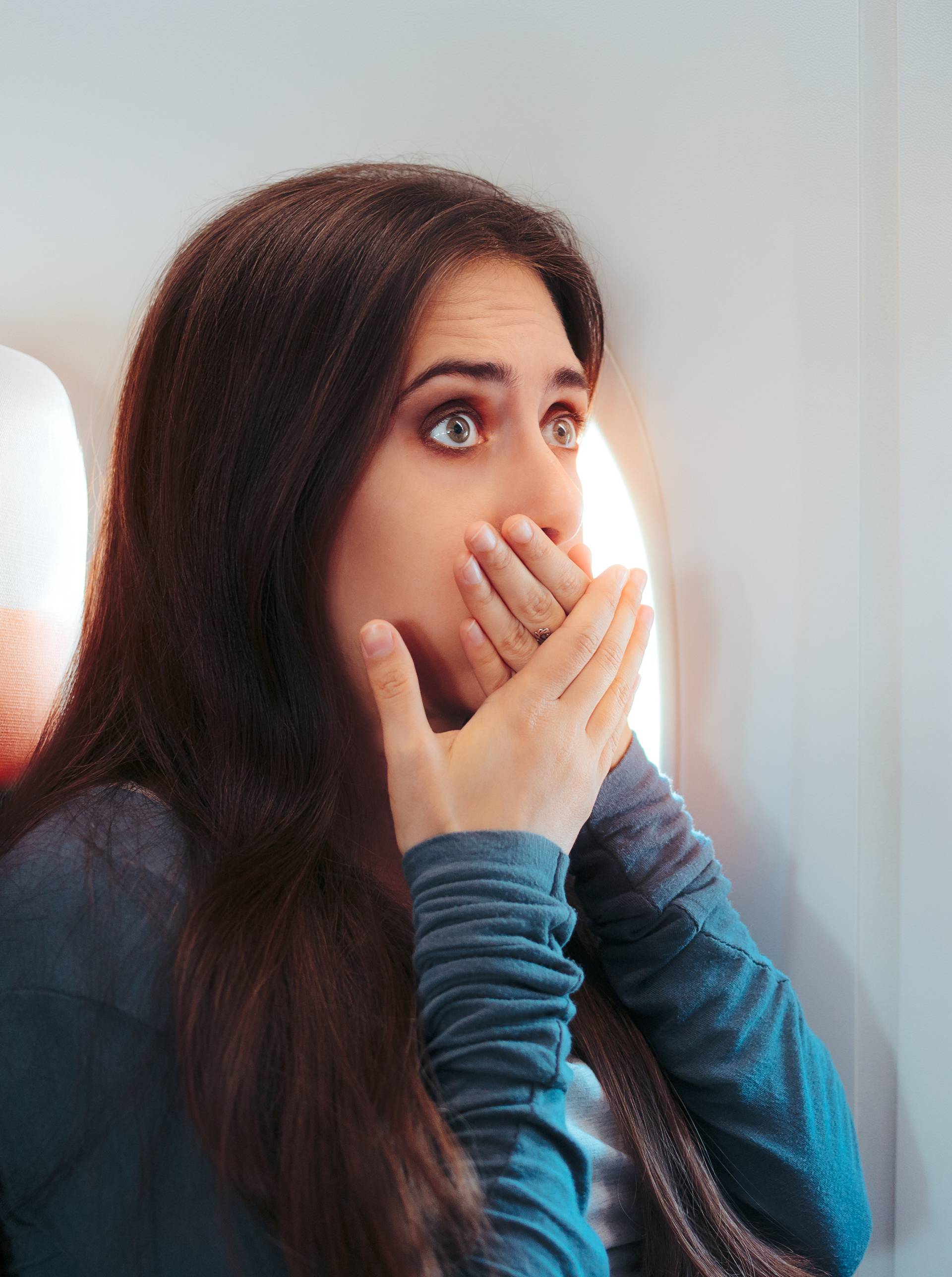 Woman Sitting By the Window on An Airplane Feeling Sick
