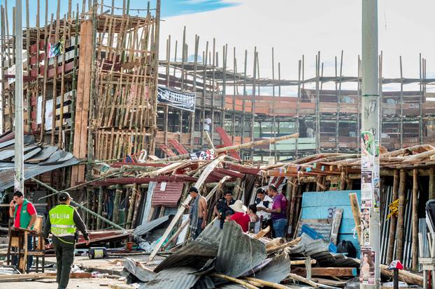 People gather near the rubble of a grandstand that collapsed in a bullring during the celebrations of the San Pedro festivities, in El Espinal