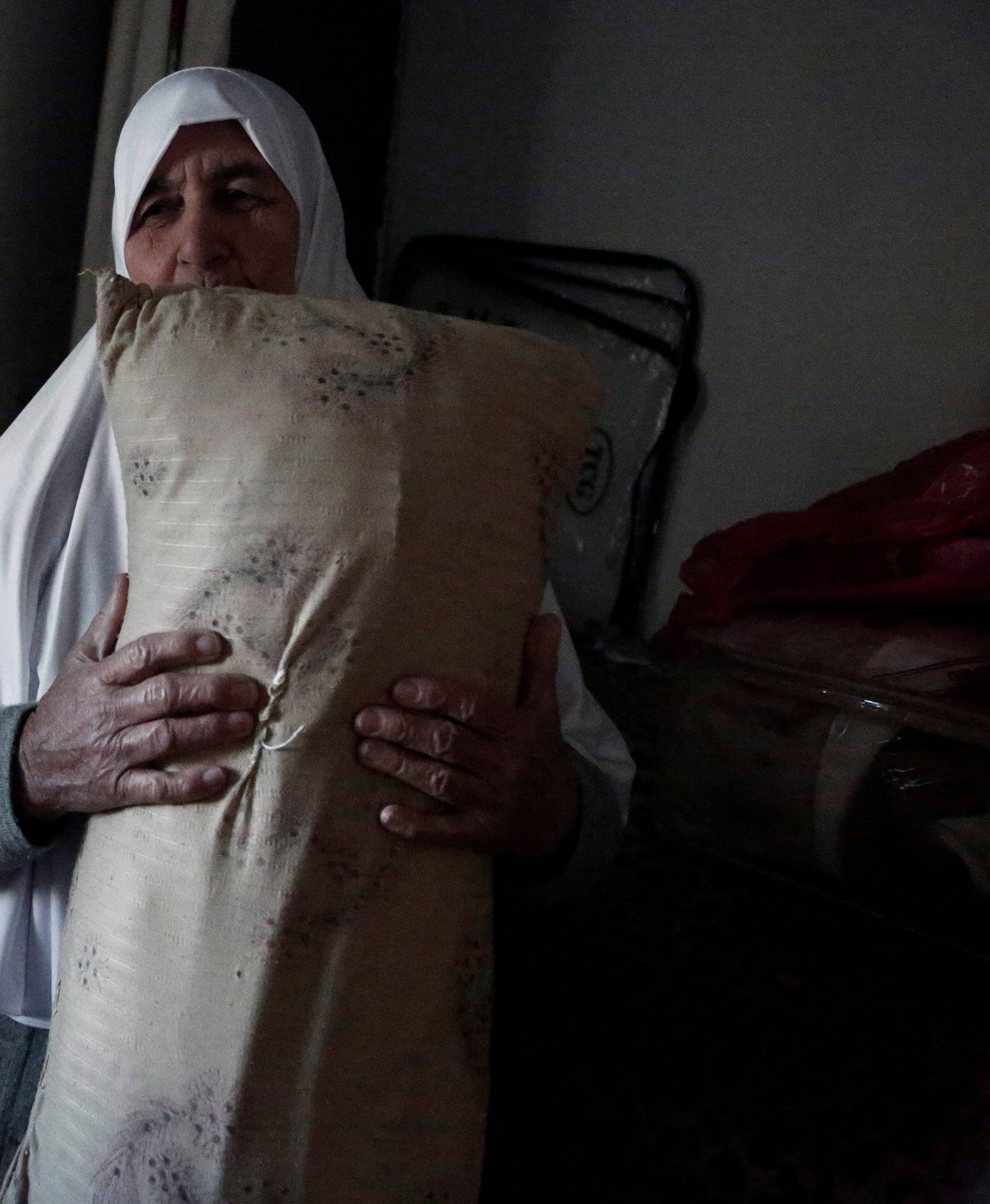 Ezzeya Daraghmeh, an 82-year-old Palestinian woman who said she has kept parts of her hair she cut over 67 years, holds a pillow that she stuffed with her hair, in the West Bank town of Tubas