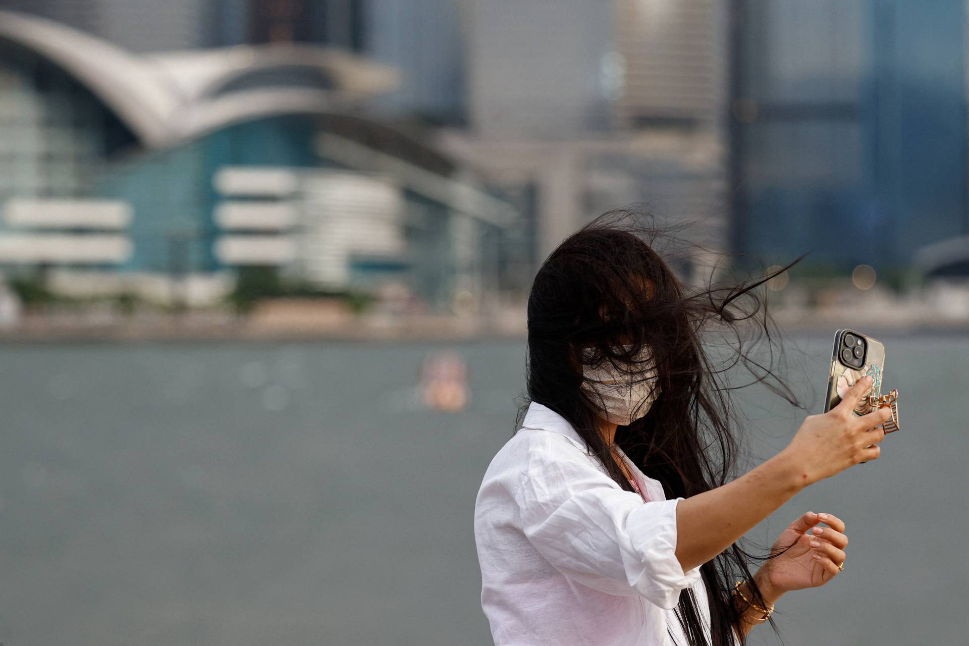 A woman takes a selfie as typhoon Yagi approaches in Hong Kong