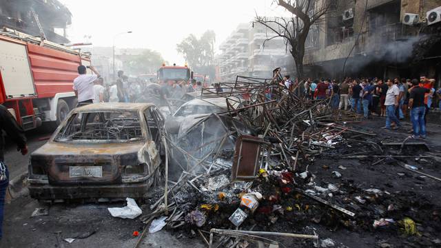 People gather at the site of a suicide car bomb in the Karrada shopping area, in Baghdad, Iraq 