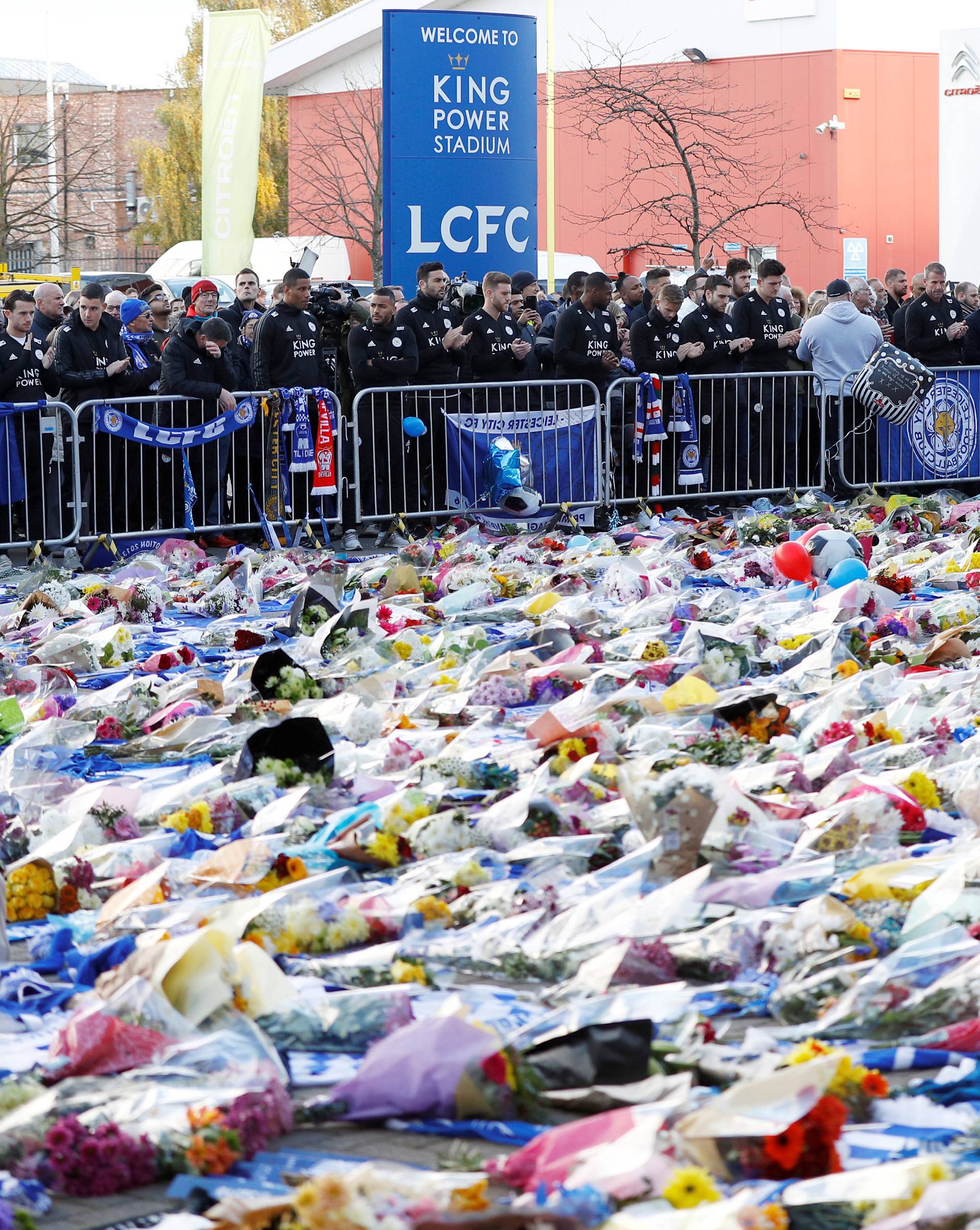 Leicester City players look at tributes left for Leicester City's owner Thai businessman Vichai Srivaddhanaprabha and four other people who died when the helicopter they were travelling in crashed in Leicester