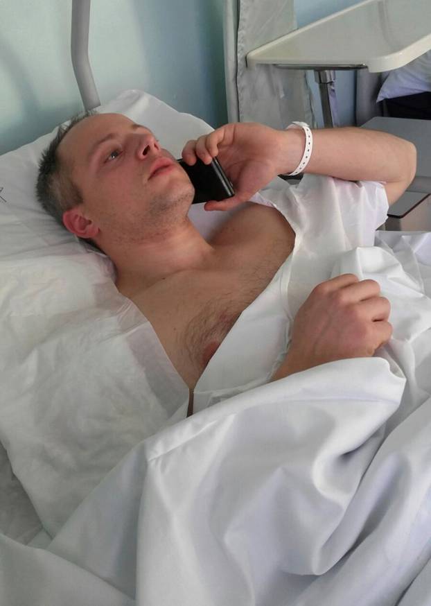 Cristian Movio, the Milan policemen who shot dead the suspect in the Berlin Christmas market truck attack, talks on a mobile phone as he lies injured in a hospital bed in Milan