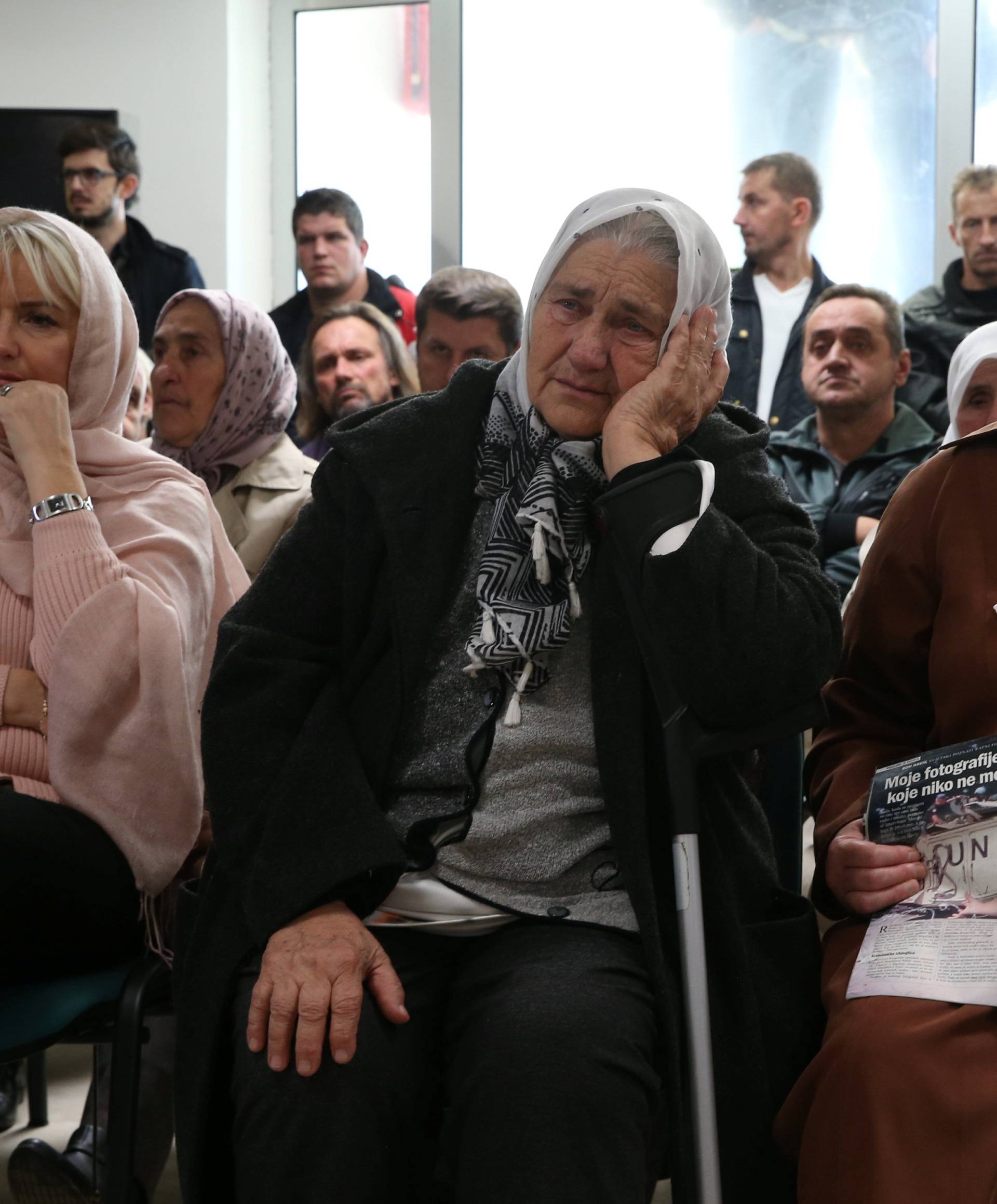 Victims and their family members watch a television broadcast of the court proceedings of former Bosnian Serb general Ratko Mladic in the Memorial centre Potocari near Srebrenica